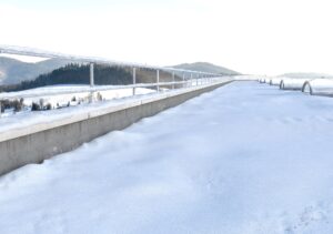Schneebedecktes Flachdach mit Attika und Lichtkuppeln